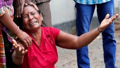 聖アンソニー教会で爆発があった後、涙を流す女性＝２１日、コロンボ