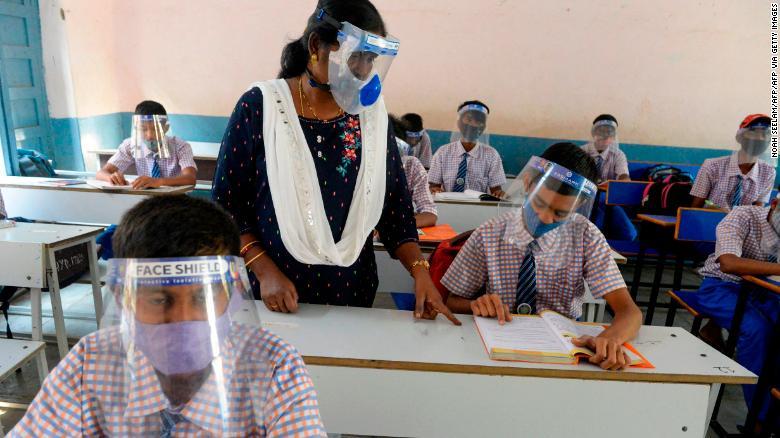 マスクとフェイスシールドを着用して授業を受ける印ハイデラバードの学校の生徒/NOAH SEELAM/AFP/Getty Images