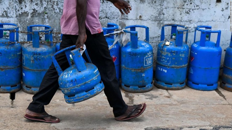 液化石油ガスの入ったボンベを持って歩く男性＝スリランカ・コロンボ/Ishara S. Kodikara/AFP/Getty Images