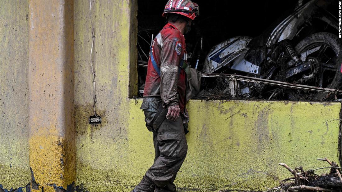 家になだれ込んだオートバイを見つめる捜索隊員＝９日/Yuri Cortez/AFP/Getty Images