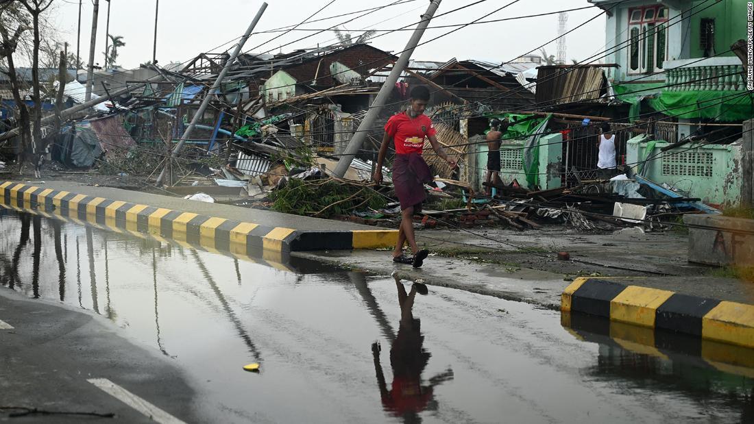 サイクロン「モカ」によって破壊された建物の前を歩く男性＝１５日、ミャンマーのラカイン州シットウェ/Sai Aung Main/AFP/Getty Images