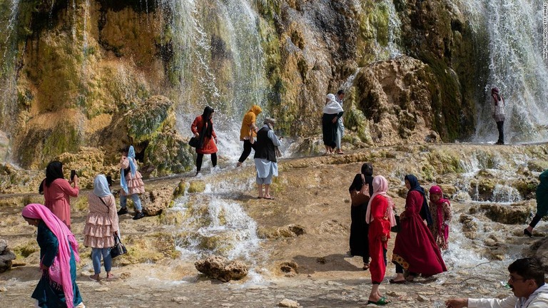 バンデ・アミール国立公園の滝のそばを歩く女性＝２２年８月１２日、アフガニスタン/Nava Jamshidi/Getty Images 