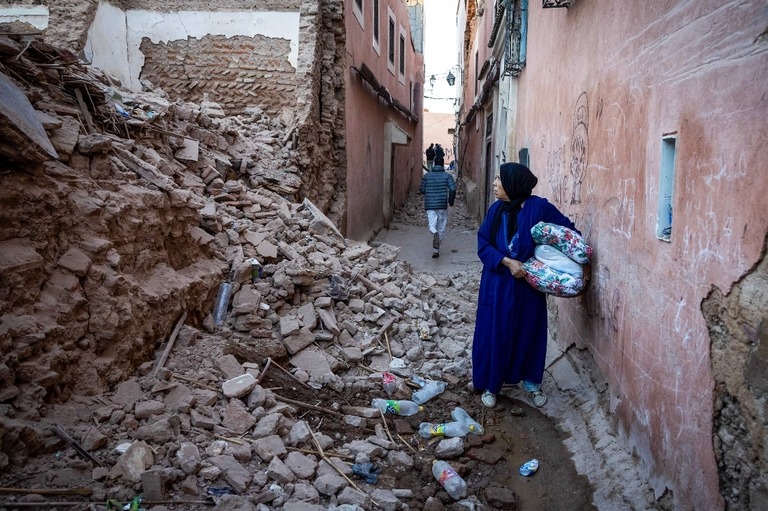 モロッコ・マラケシュで地震のため瓦礫と化した建物を見つめる女性/Fadel Senna/AFP/Getty Images