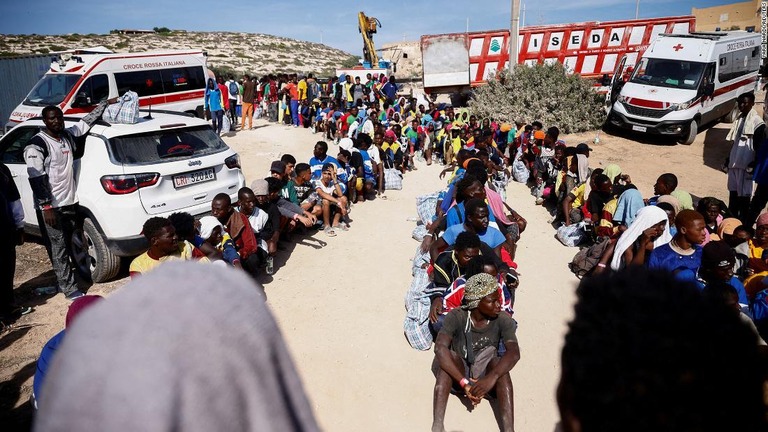 ランペドゥーザ島で伊本土への移送を待って列に並ぶ移民たち/Yara Nardi/Reuters