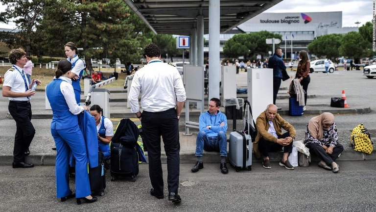 仏南西部トゥールーズの空港で、施設の外に避難する旅行者や空港職員ら/Charly Triballeau/AFP/Getty Images