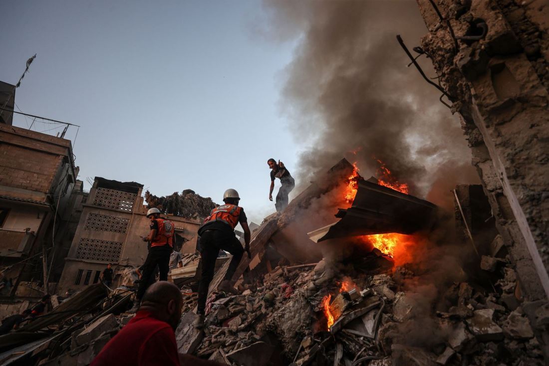 消火とともにがれきの中の生存者を捜索する人々＝１１月４日、パレスチナ自治区ガザ地区ハンユニス/Mustafa Hassona/Anadolu/Getty Images
