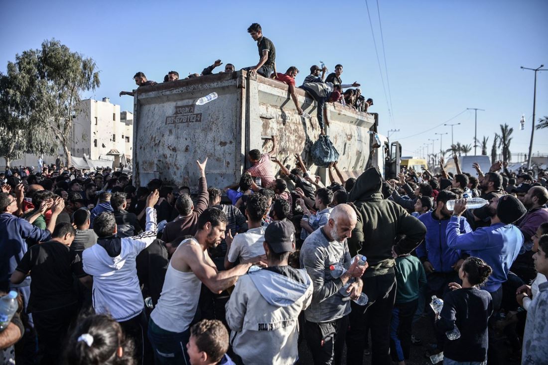 配給されるペットボトルの水を求める人々＝１２月１１日、パレスチナ自治区ガザ地区ラファ/Stringer/Anadolu/Getty Images