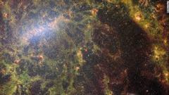 ウェッブ望遠鏡の中間赤外線装置「ＭＩＲＩ」と近赤外線カメラ「ＮＩＲＣａｍ」で撮影された合成画像。棒渦巻銀河「ＮＧＣ５０６８」の恒星やちりを捉えている