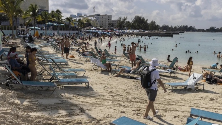 バハマのビーチを楽しむ観光客ら＝２０２２年１２月/Victor J. Blue/Bloomberg/Getty Images