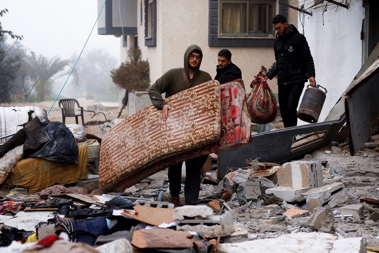 イスラエルによる攻撃を受けた現場の家屋から家財道具を運び出す住民＝９日、ラファ/Ibraheem Abu Mustafa/Reuters