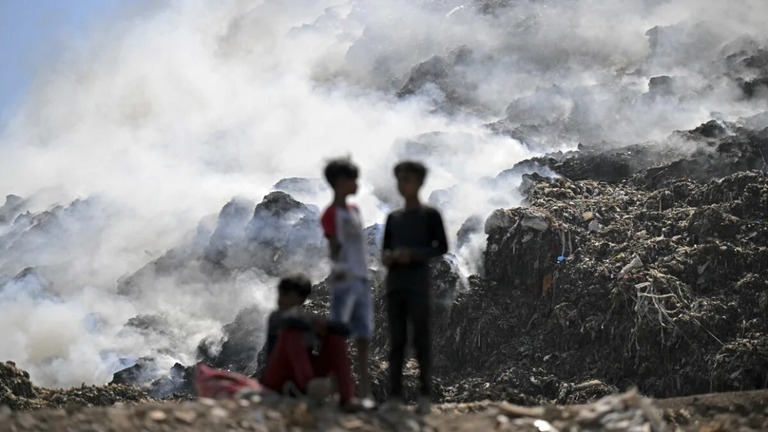埋め立て地で発生した火災から立ち上る煙/Money Sharma/AFP/Getty Images
